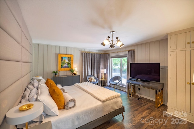 bedroom with a chandelier and dark wood finished floors