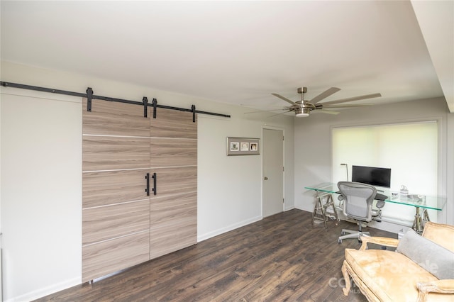 office space featuring wood finished floors, a barn door, ceiling fan, and baseboards