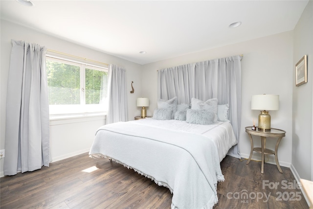 bedroom with baseboards and wood finished floors