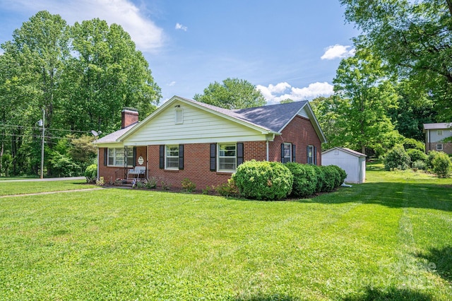view of front facade featuring a storage shed, brick siding, a chimney, and a front lawn