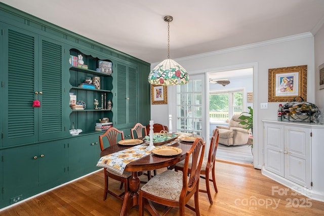 dining room featuring crown molding and light wood-style flooring