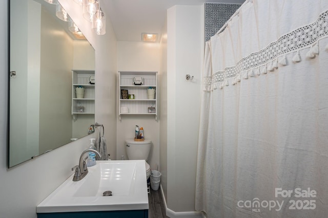 bathroom with vanity, baseboards, toilet, and wood finished floors
