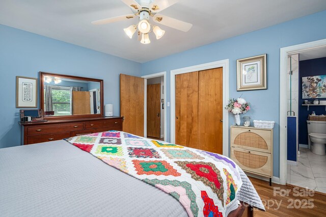 bedroom featuring ceiling fan, baseboards, a closet, marble finish floor, and ensuite bath