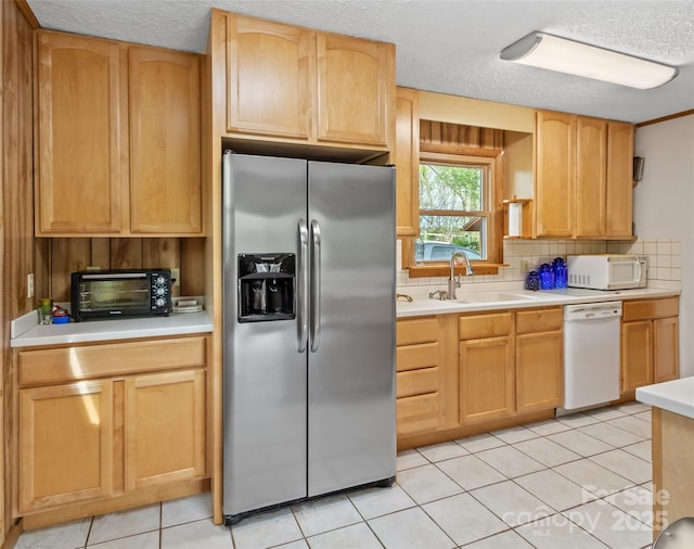 kitchen featuring white appliances, backsplash, a sink, and light countertops