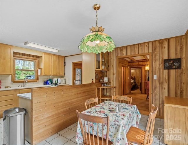 dining space with wood walls and light tile patterned floors