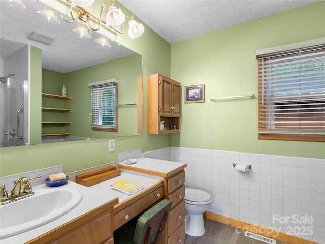bathroom featuring a textured ceiling, visible vents, tile walls, vanity, and toilet