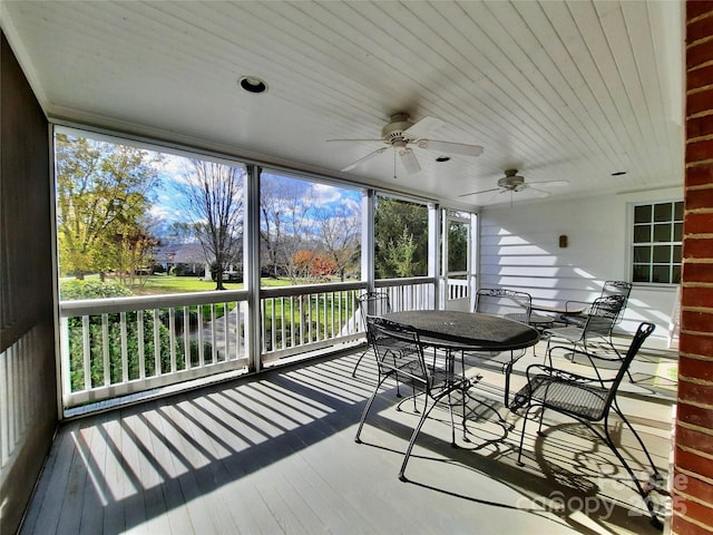 sunroom / solarium with a ceiling fan and outdoor dining area