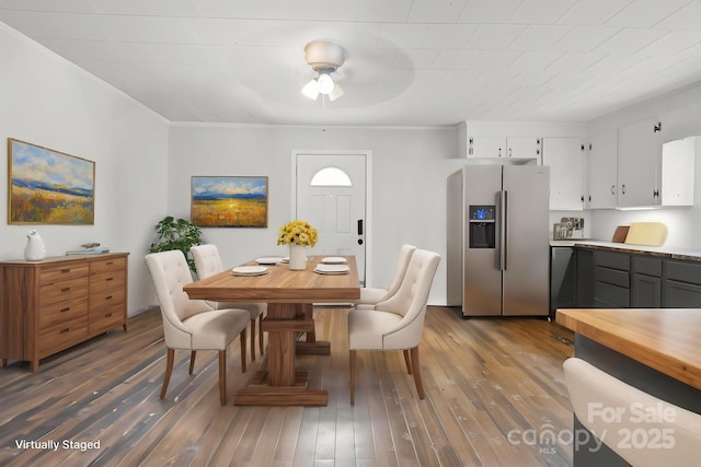 dining area with dark wood finished floors, ornamental molding, and a ceiling fan