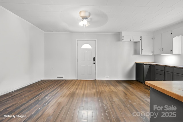 interior space with dark wood-style floors, ceiling fan, crown molding, white cabinetry, and light countertops