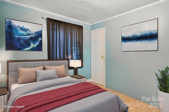 bedroom featuring ornamental molding and wood finished floors