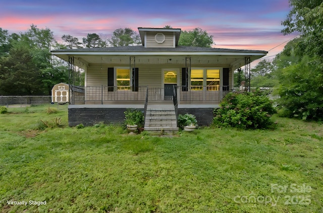 bungalow featuring covered porch, fence, an outdoor structure, and a shed
