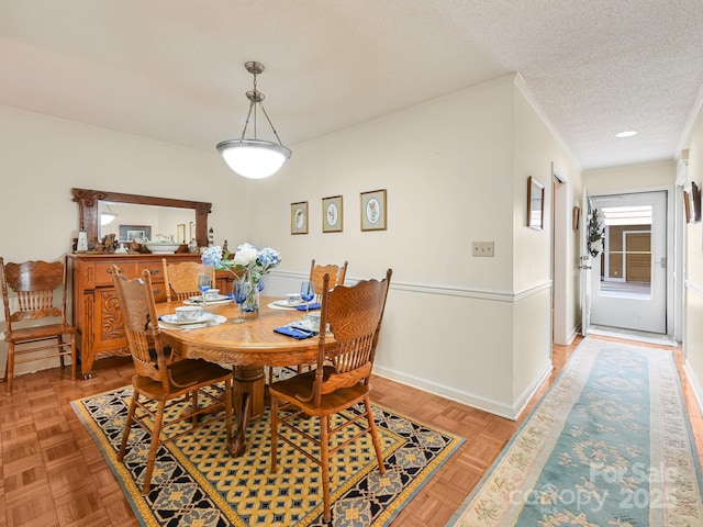 dining room with a textured ceiling and baseboards