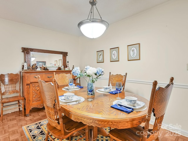 dining space featuring baseboards and crown molding