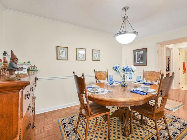 dining room with ornamental molding and baseboards
