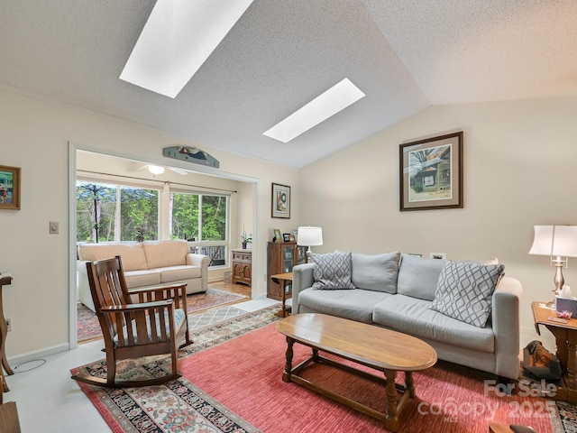 living room with lofted ceiling with skylight, baseboards, and a textured ceiling