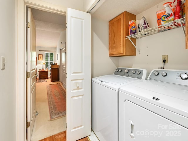 laundry room with washing machine and clothes dryer and cabinet space