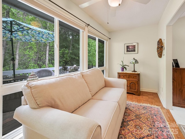 living room featuring ceiling fan and baseboards