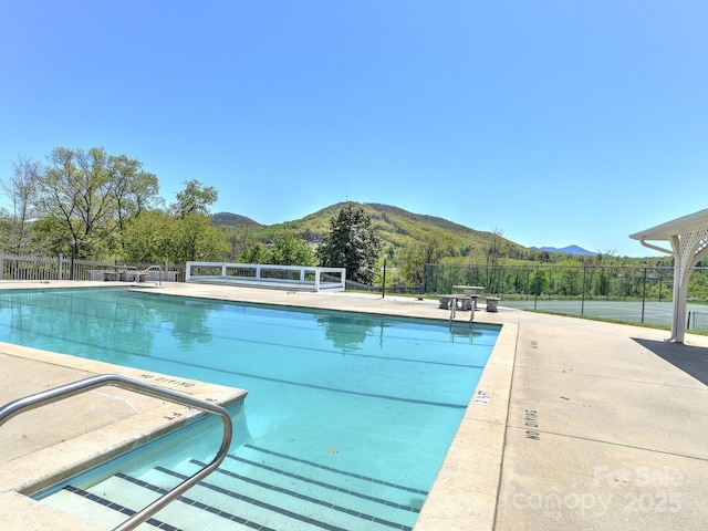 pool featuring a mountain view and fence