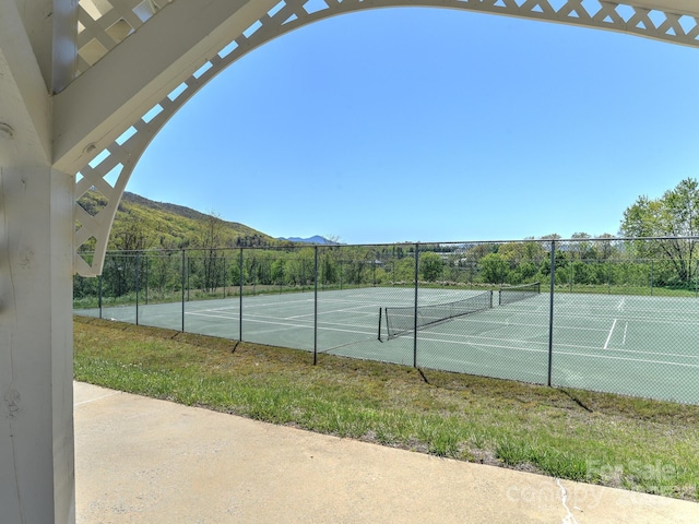 view of sport court featuring a mountain view and fence