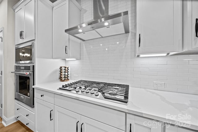 1287 Fishing Creek Rd, Lake Wylie, SC 29710 - kitchen featuring stainless steel appliances, wall chimney exhaust hood, decorative backsplash, and white cabinetry