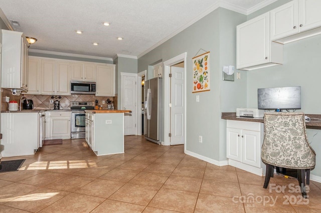 kitchen featuring crown molding, a kitchen island, tasteful backsplash, appliances with stainless steel finishes, and light tile patterned floors
