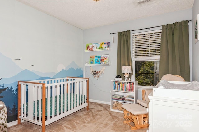 bedroom with visible vents, baseboards, a textured ceiling, a nursery area, and carpet