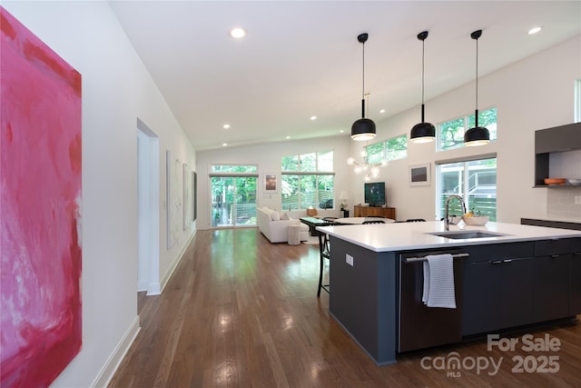 kitchen with dark wood-style flooring, stainless steel dishwasher, a sink, light countertops, and recessed lighting