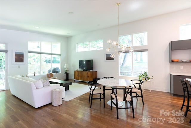 living room featuring a chandelier, wood finished floors, and a wealth of natural light