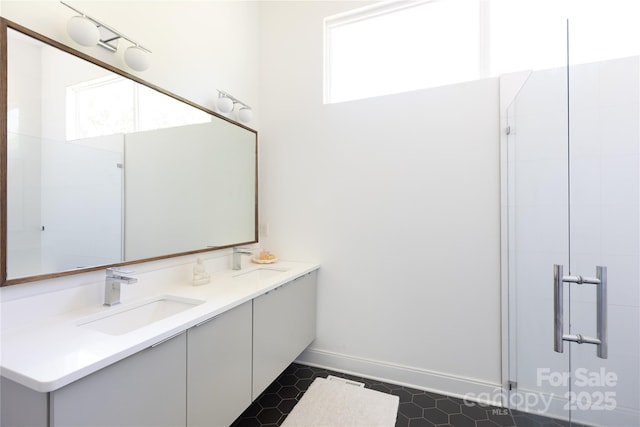 full bathroom with double vanity, a sink, and a wealth of natural light