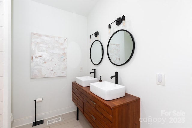full bathroom featuring visible vents, a sink, baseboards, and double vanity