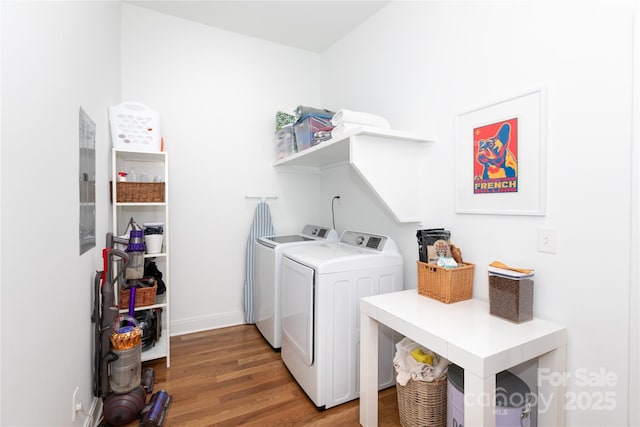 laundry area with baseboards, laundry area, light wood finished floors, and washing machine and clothes dryer