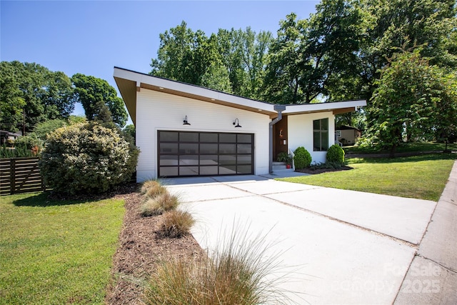 contemporary home featuring an attached garage, driveway, and a front yard