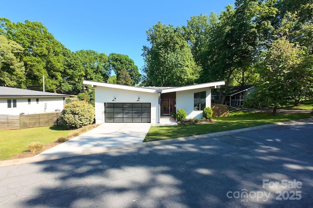 view of front of house featuring an attached garage, driveway, and a front yard