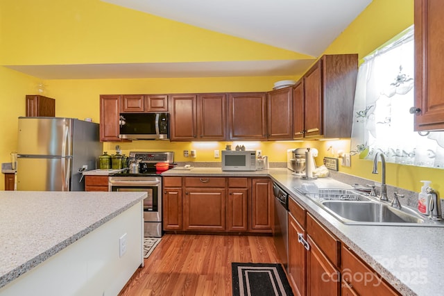 814 Independence Dr, Wingate, NC 28174 - kitchen featuring lofted ceiling, light wood-style floors, light countertops, a sink, and stainless steel appliances
