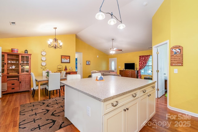 814 Independence Dr, Wingate, NC 28174 - kitchen with visible vents, pendant lighting, lofted ceiling, and light wood-style floors