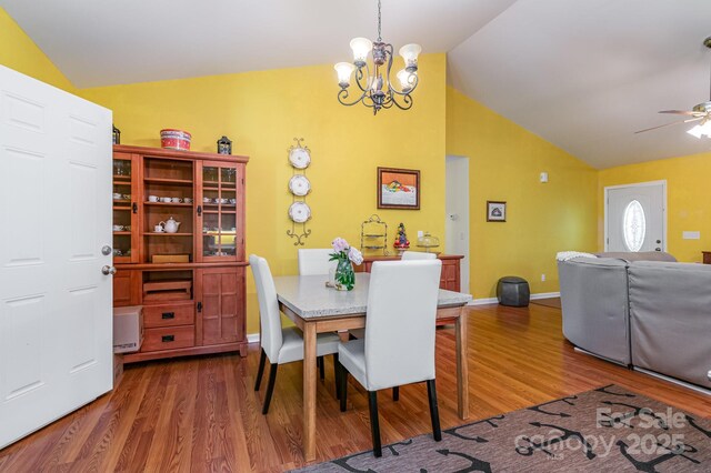 814 Independence Dr, Wingate, NC 28174 - dining space featuring ceiling fan with notable chandelier, baseboards, vaulted ceiling, and wood finished floors