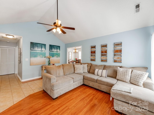 living room featuring ceiling fan, high vaulted ceiling, a chandelier, baseboards, and light tile patterned flooring