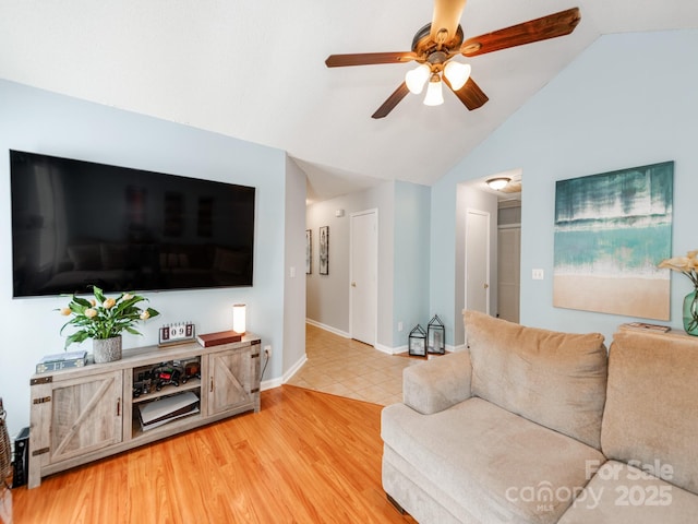 living area featuring lofted ceiling, ceiling fan, baseboards, and light wood-type flooring