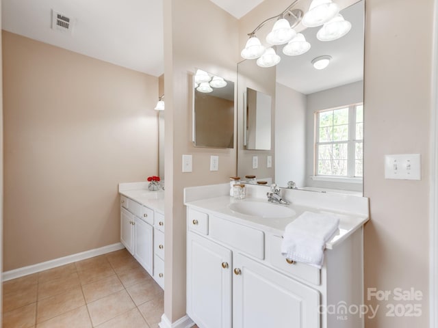 bathroom featuring vanity, tile patterned flooring, baseboards, and a chandelier