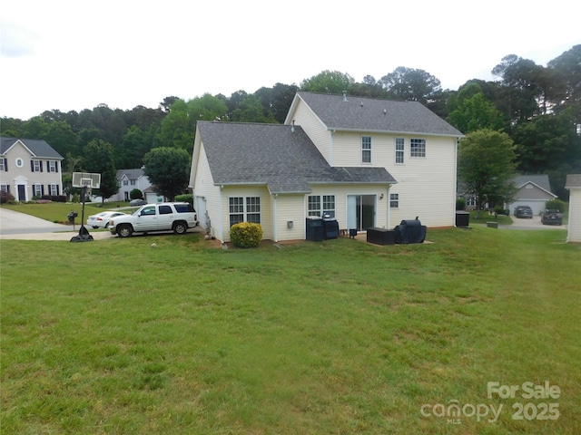 back of property with a yard and a shingled roof