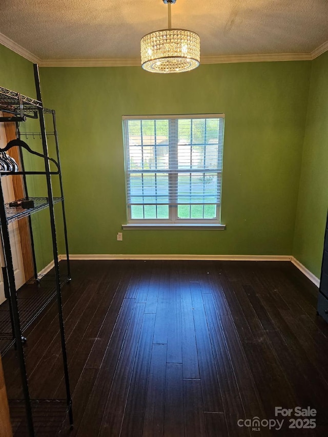 spare room featuring baseboards, a chandelier, and wood-type flooring