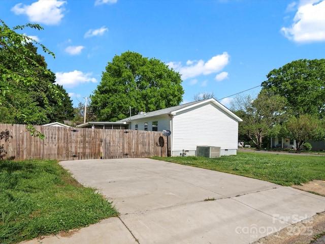 view of side of property with cooling unit, a gate, crawl space, a yard, and fence private yard