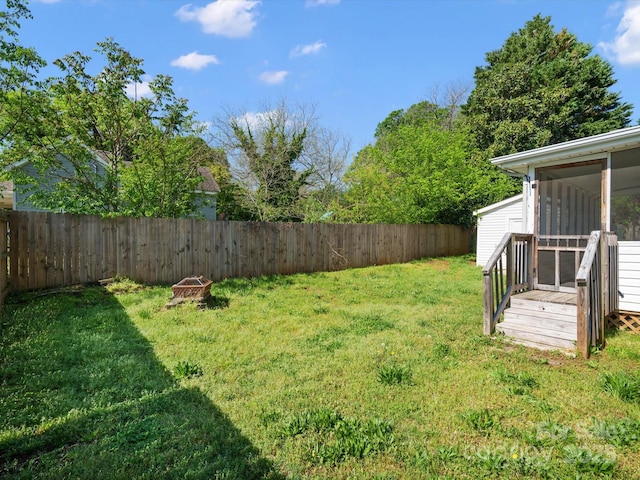 view of yard with a sunroom and a fenced backyard