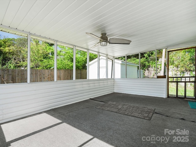 unfurnished sunroom featuring ceiling fan
