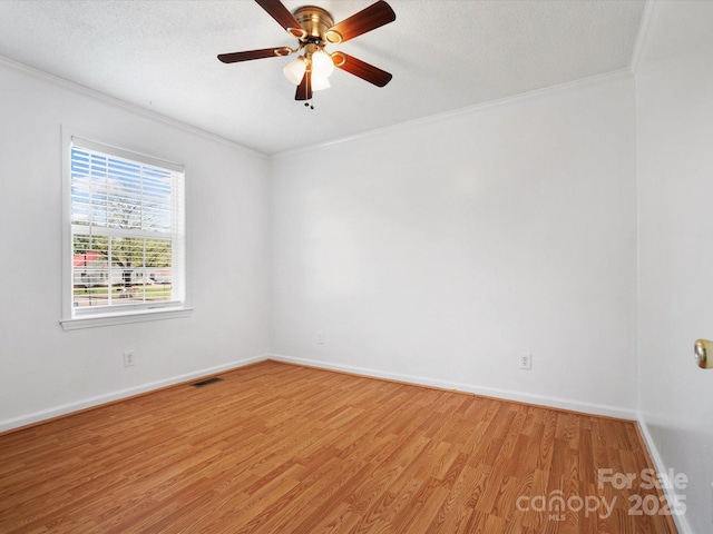 unfurnished room featuring ceiling fan, crown molding, light wood finished floors, and baseboards
