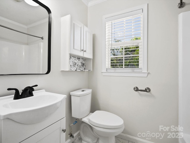 bathroom featuring vanity, toilet, ornamental molding, and baseboards