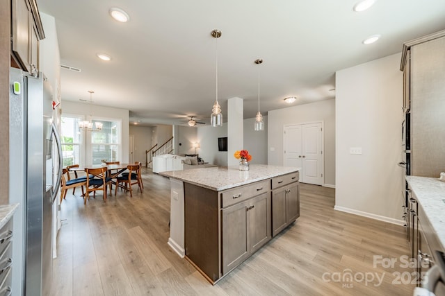 804 Lyndon Station Dr, Pineville, NC 28134 - kitchen with hanging light fixtures, stainless steel fridge, light wood-style flooring, and a center island