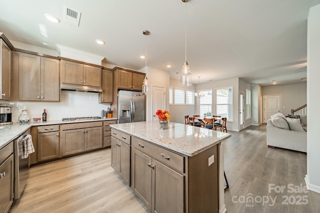 804 Lyndon Station Dr, Pineville, NC 28134 - kitchen with appliances with stainless steel finishes, decorative backsplash, under cabinet range hood, and light wood finished floors