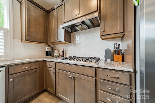 804 Lyndon Station Dr, Pineville, NC 28134 - kitchen featuring stainless steel appliances, backsplash, under cabinet range hood, and light stone counters