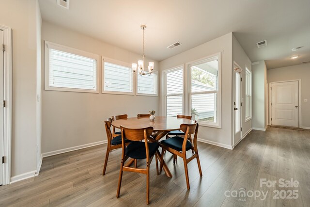 804 Lyndon Station Dr, Pineville, NC 28134 - dining room with baseboards, light wood finished floors, a chandelier, and visible vents